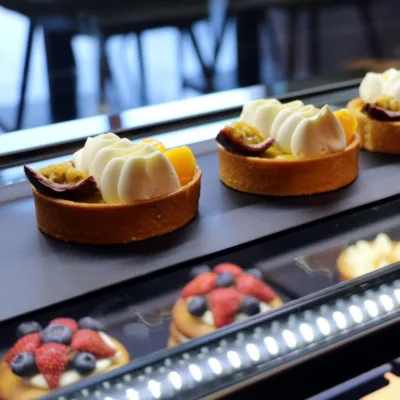 Tartelettes met room en passievrucht, daarachter tartelettes met aardbei en bosbes